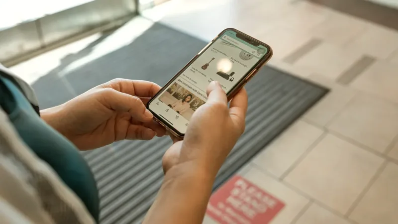Close-up of hands holding a smartphone showing an online store app, for ecommerce mobile app development on iOS and Android