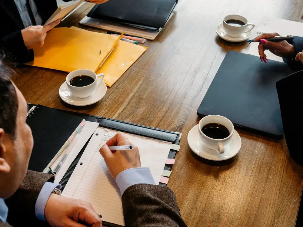 Business meeting table with notes and coffee during a store audit