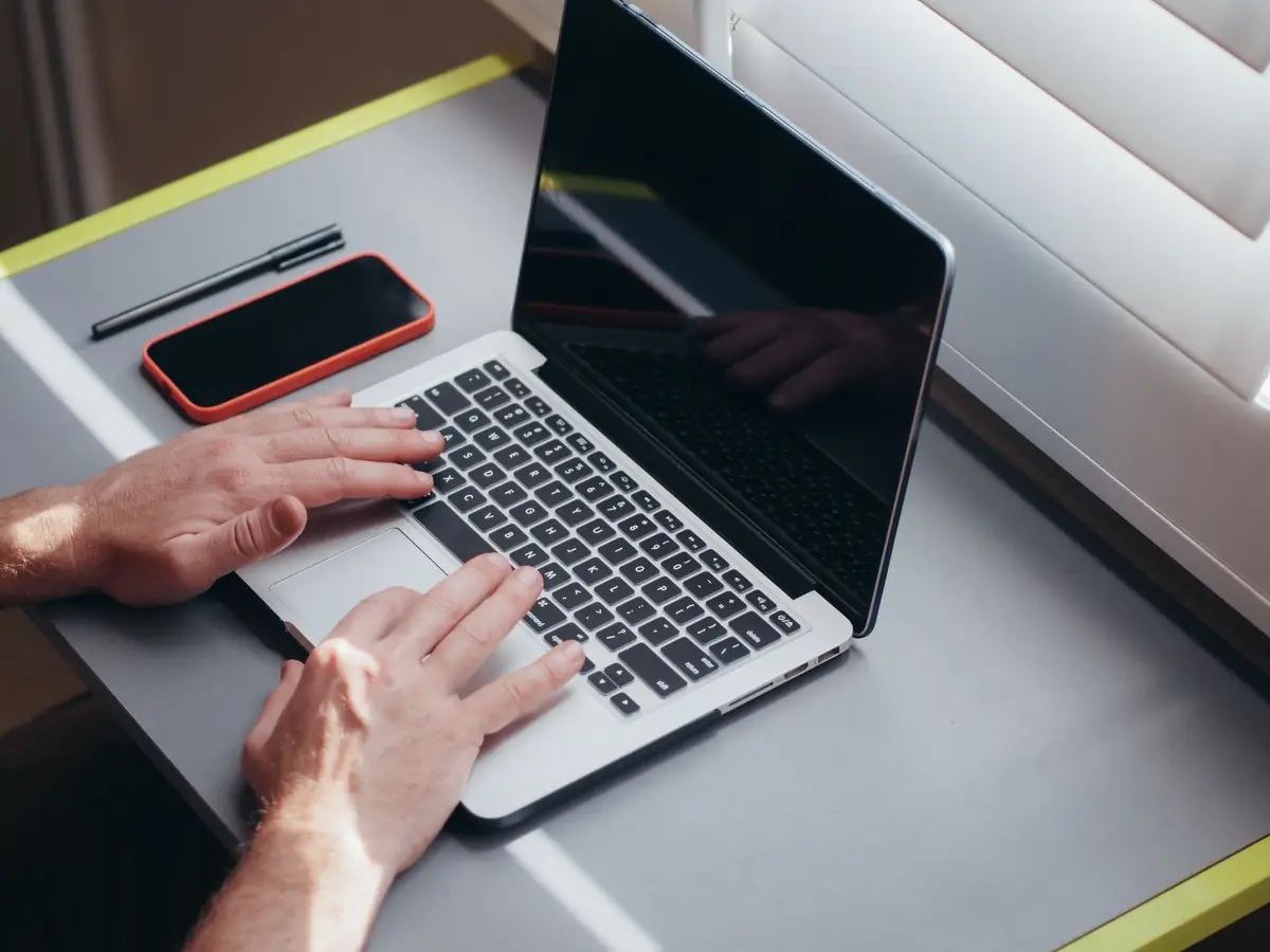 Store owner reviewing storefront performance on a laptop and phone