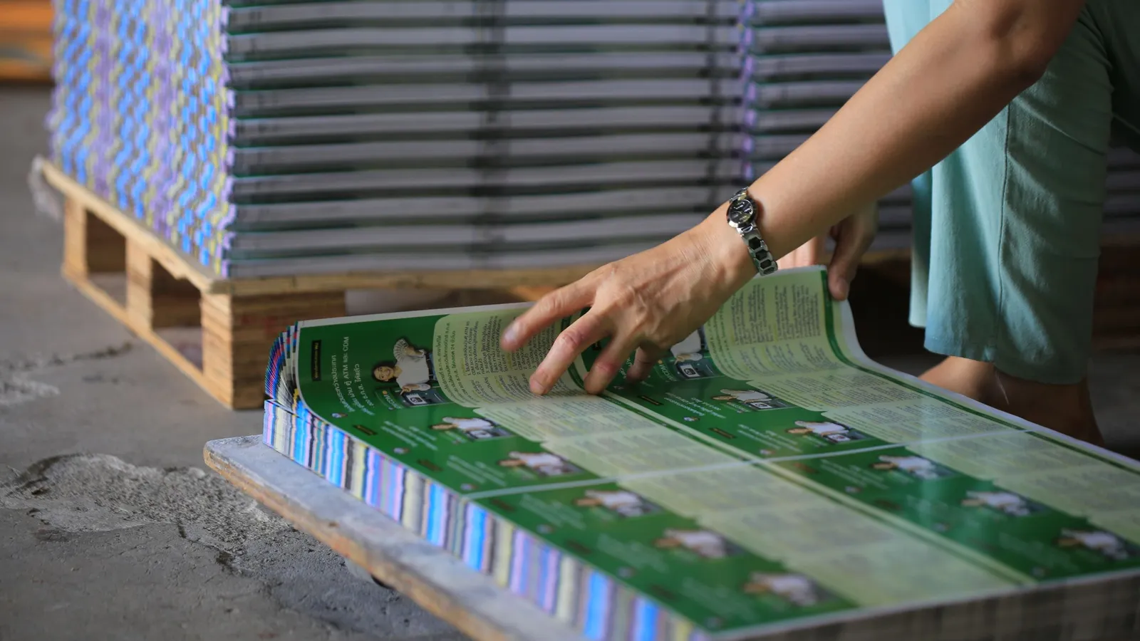 Printed sheets stacked on a pallet after a print run, priced online with a WooCommerce price matrix